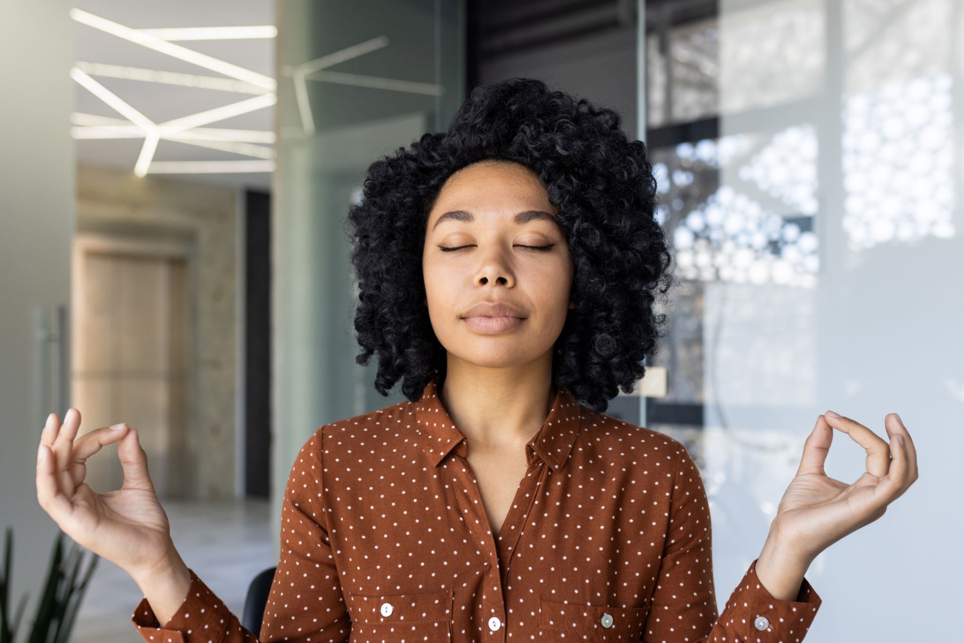 Young woman meditating peacefully in a modern office